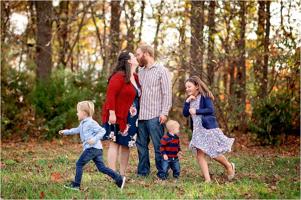 Playful and fun family portrait of children running around parents