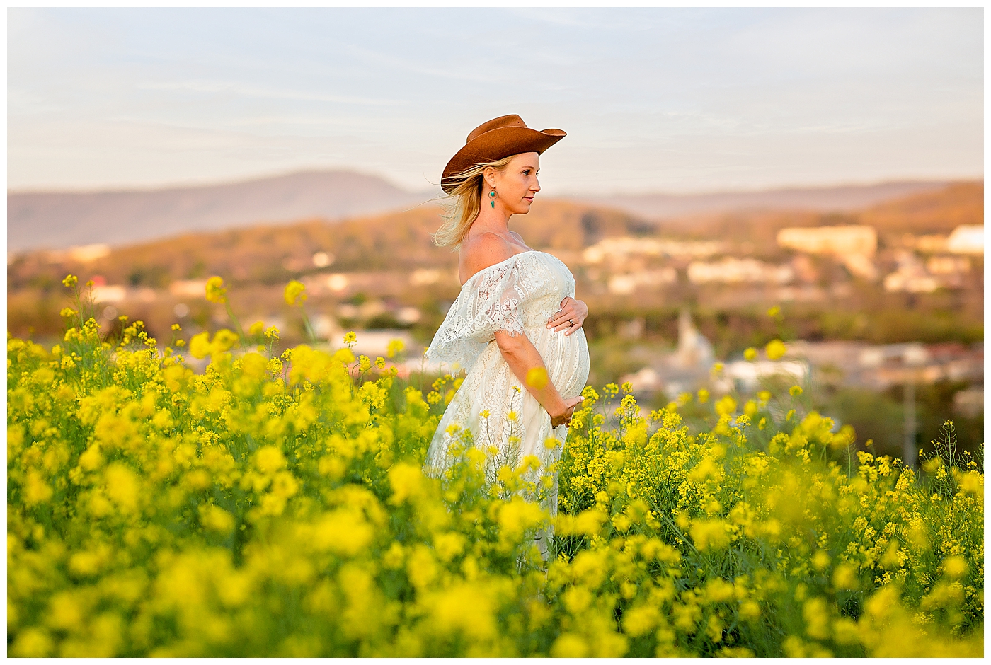 Harrisonburg maternity photo in a field of flower with a view of the mountains