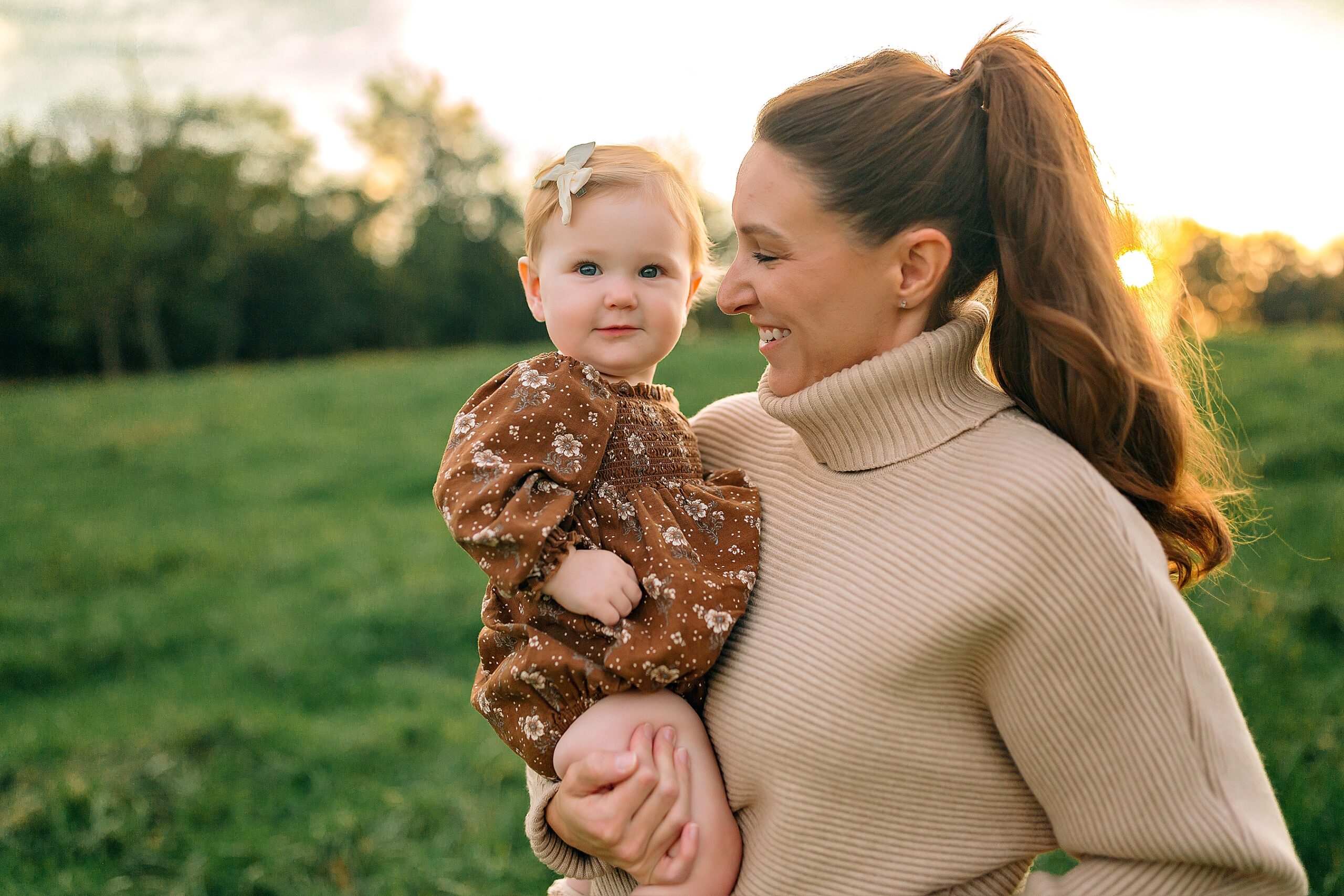 Mom holding baby wearing brown