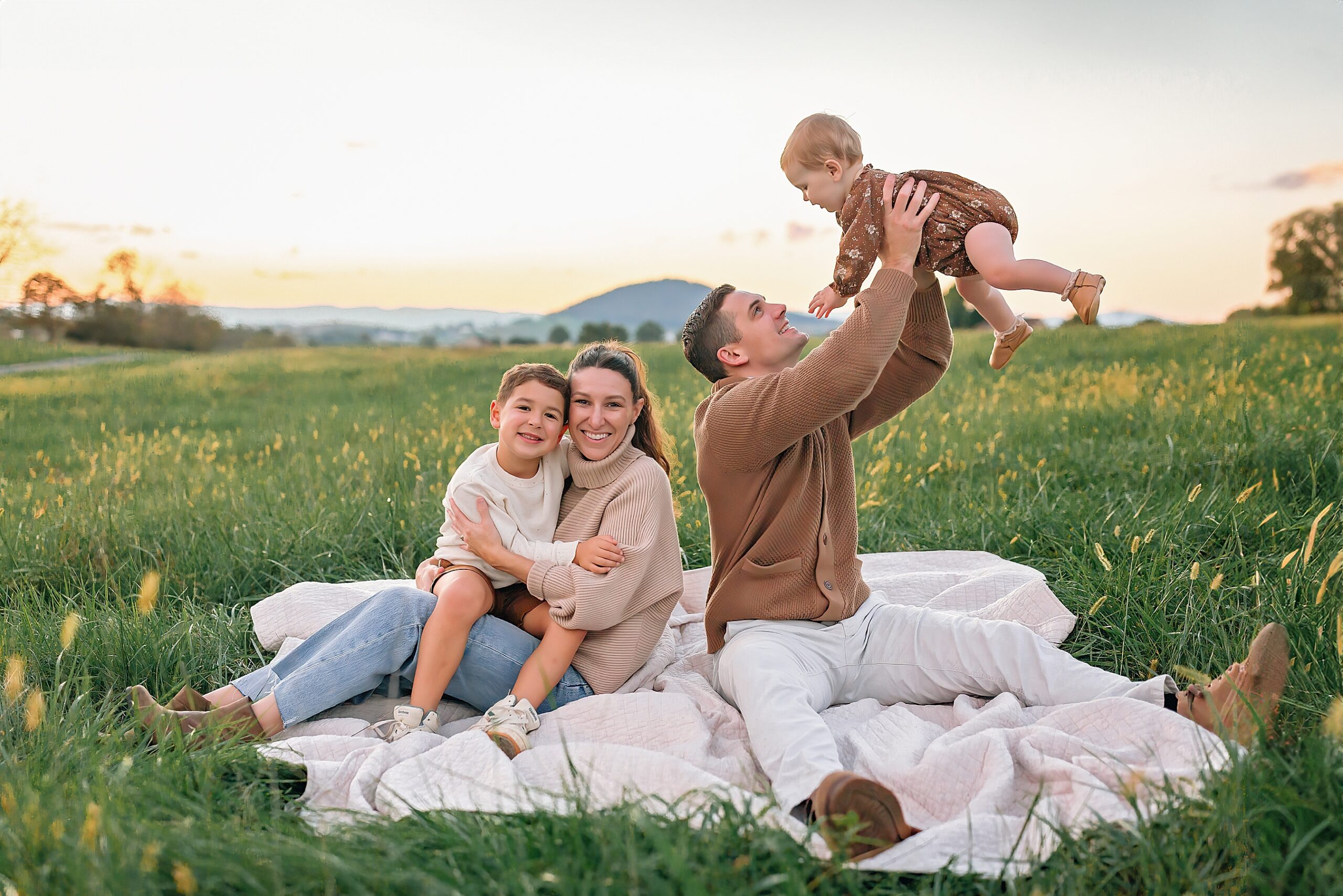 Family sitting in a field for photographs