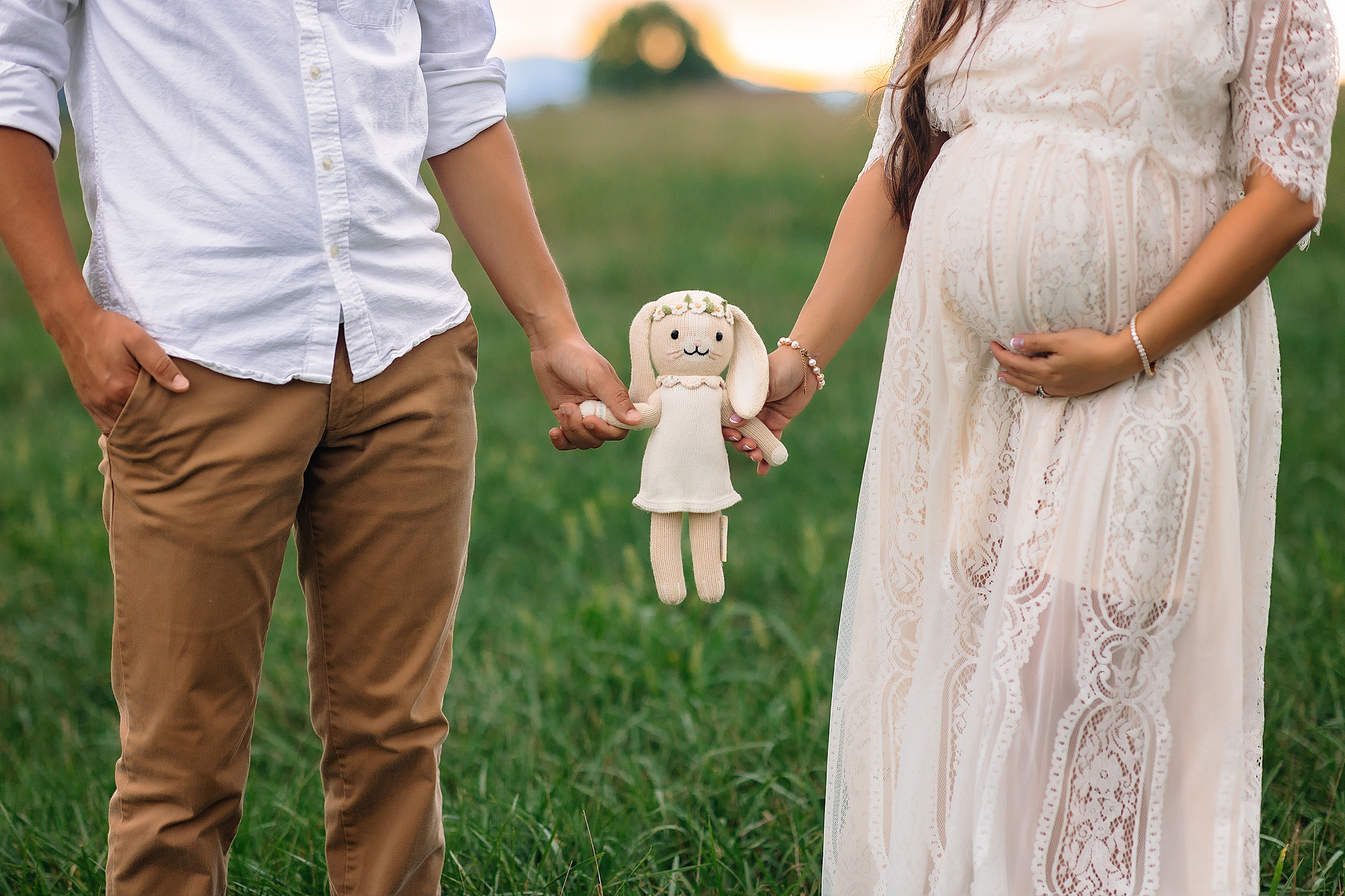 Maternity photo of mom and dad holding stuffed bunny toy