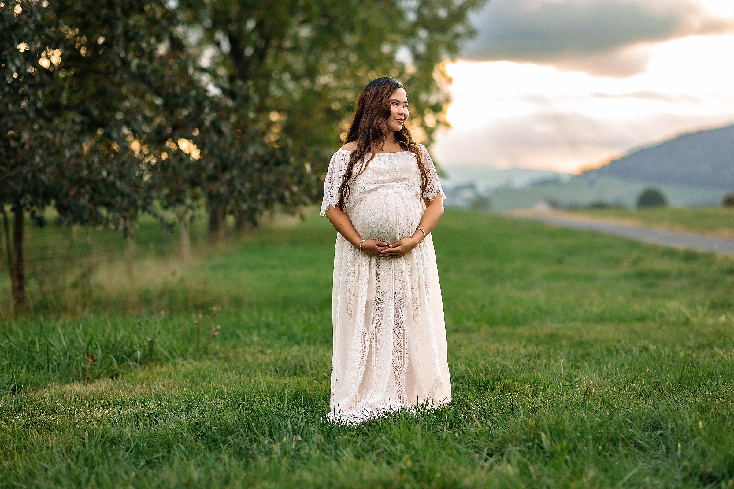 Maternity session of woman in a white dress at sunset