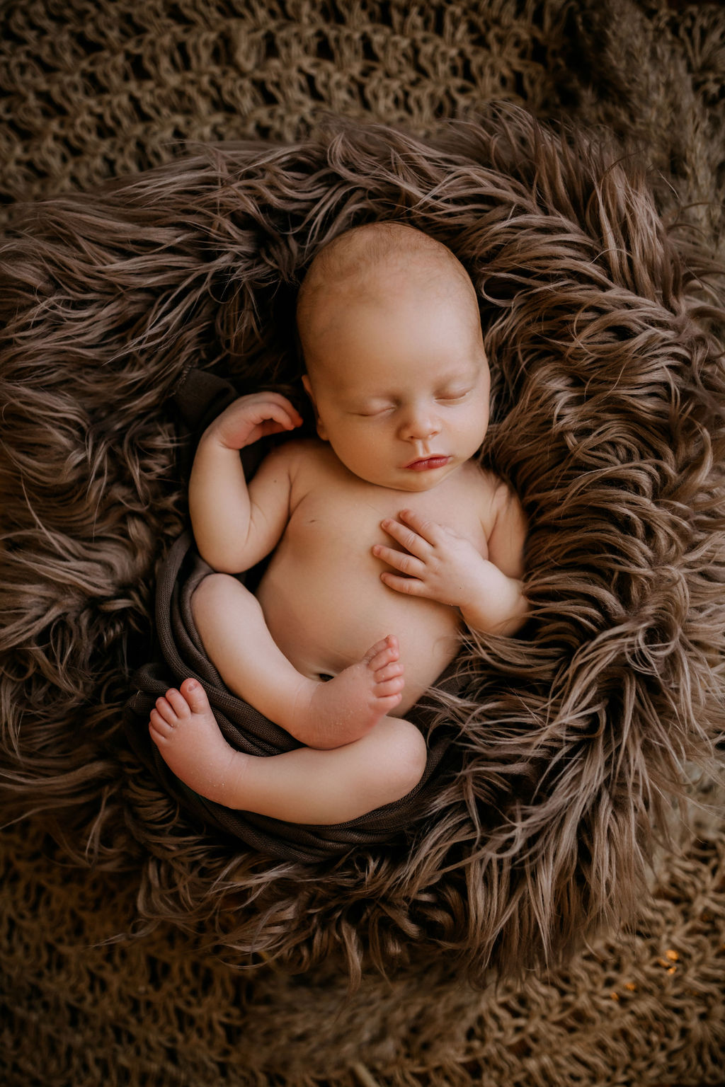 Newborn baby sleeps naked in a brown fur blanket first impressions stephens city