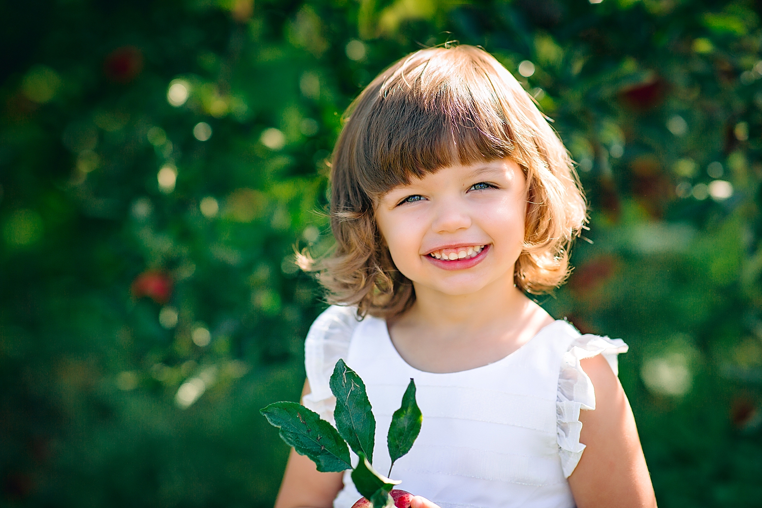 Little girl in a white dress in an orchard near Harrisonburg, VA