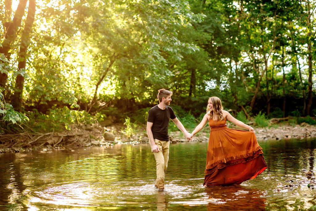 A couple dances and plays in a shallow river at sunset christian counselors in harrisonburg va