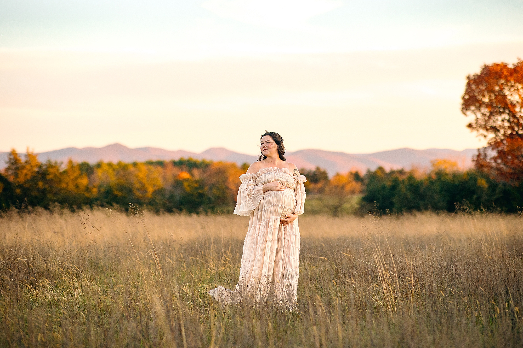Maternity session at sunset in Harrisonburg in the fall. Woman standing in a field