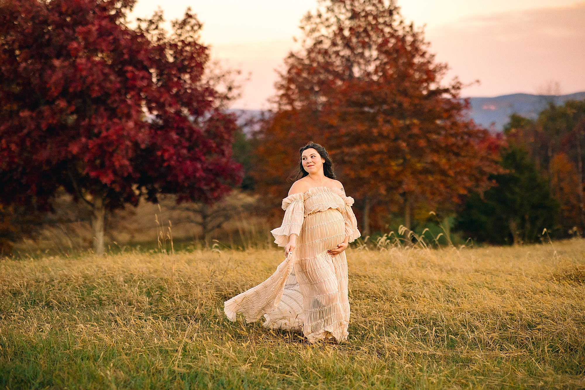 Pregnant woman in a cream dress in the fall in Harrisonburg