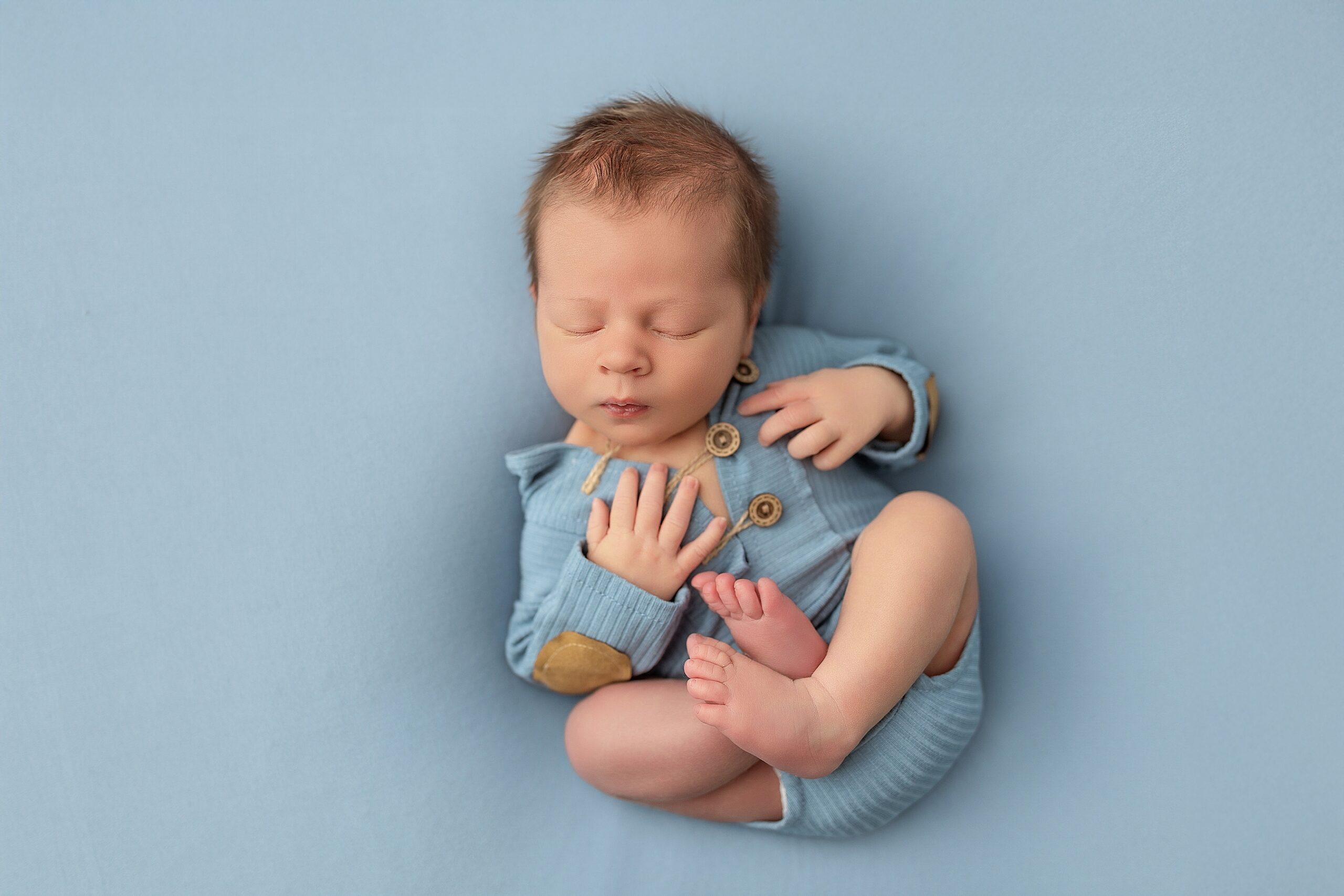 Newborn boy on blue fabric at studio in Harrisonburg VA