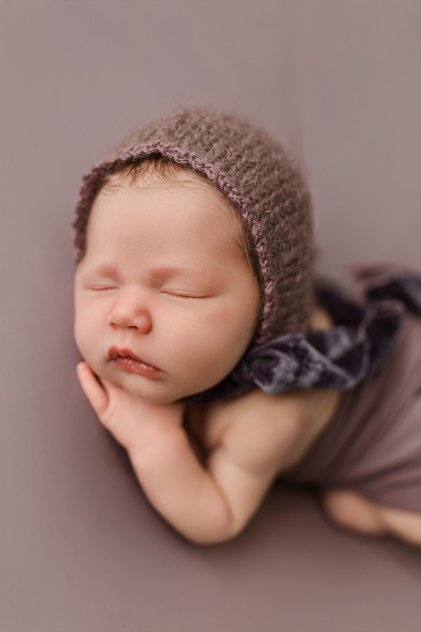 Newborn baby girl on purple