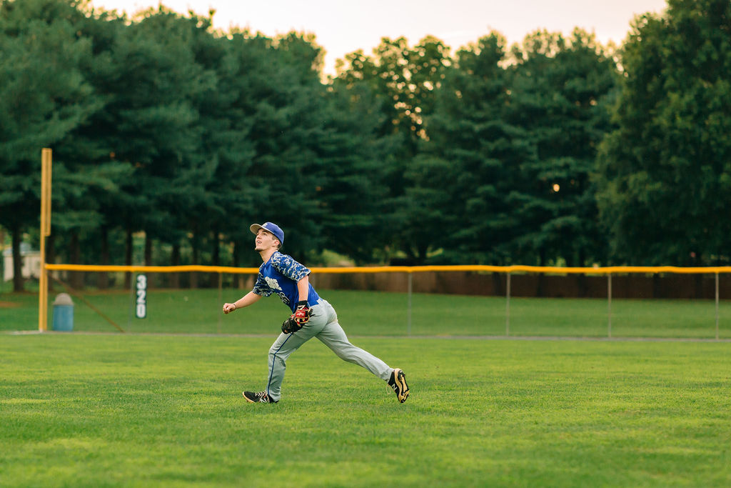 A high school grad fetches a fly ball in the outfield
